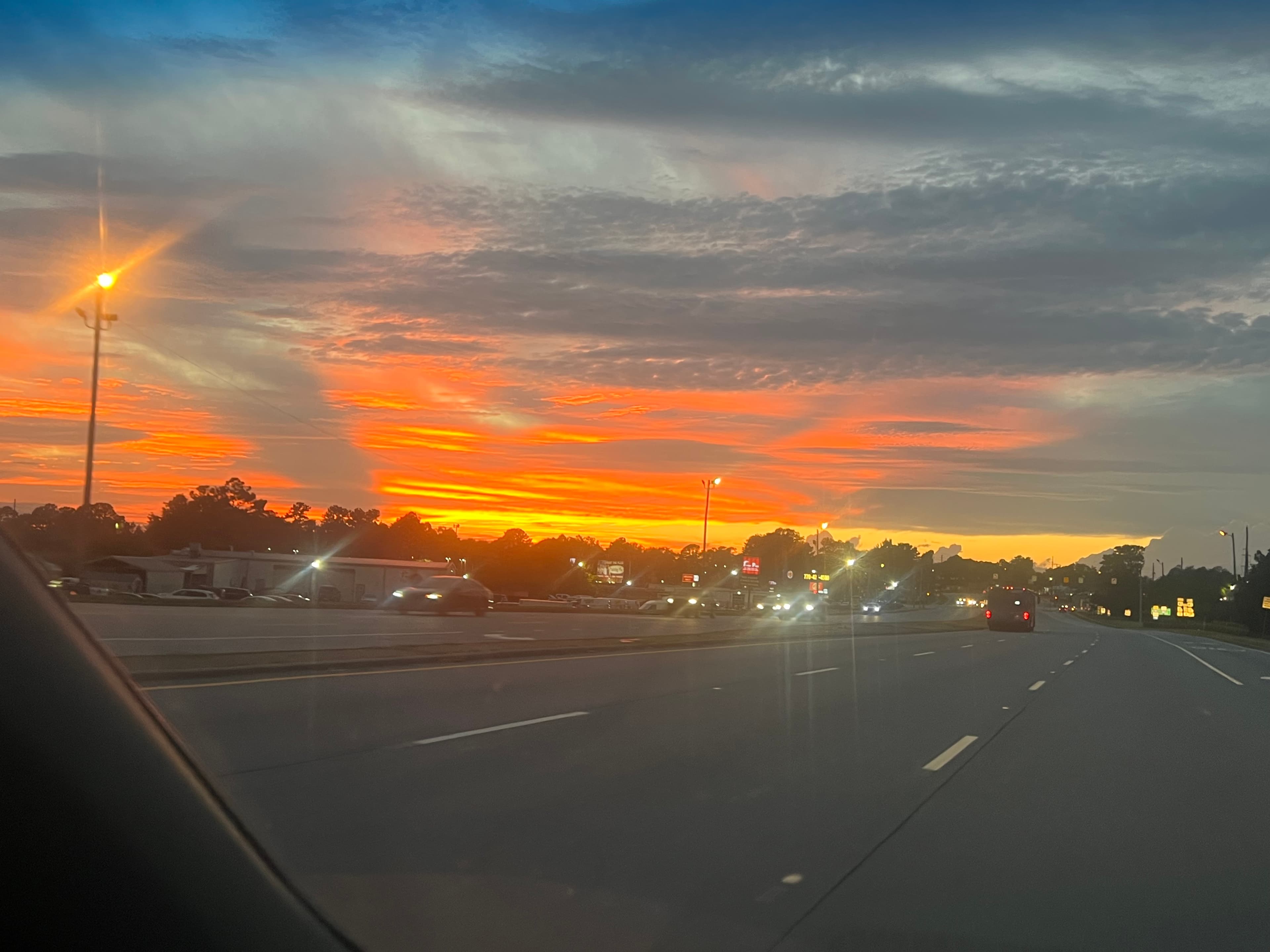 Sunset viewed through a car windshield on the highway