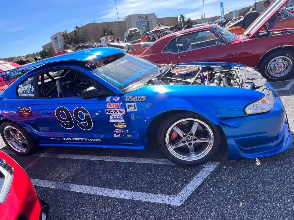 Blue modified Mustang at an outdoor car meet